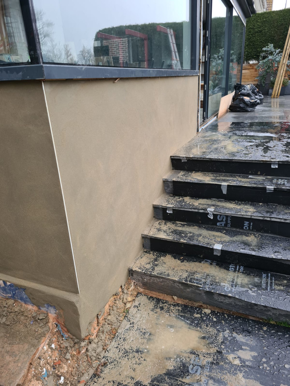 Apply top layer of waterproof render to brickwork.